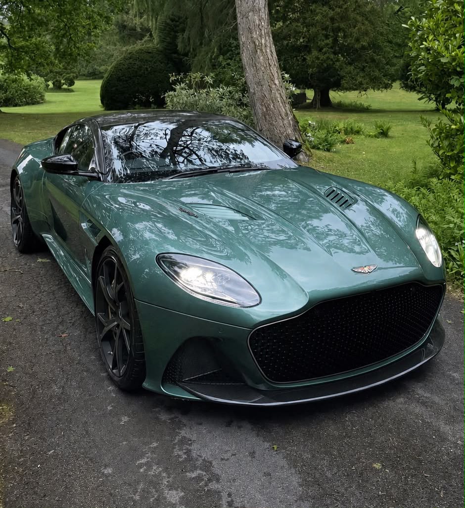 A highly polished green Aston Martin DBS Superleggera photographed outdoors
